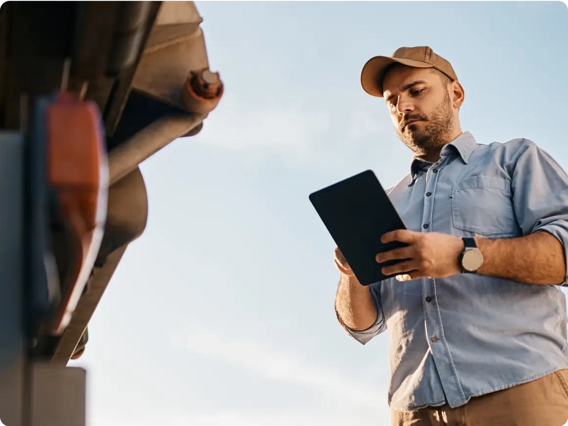 Photo of a person holding a tablet displaying the RouteMate app